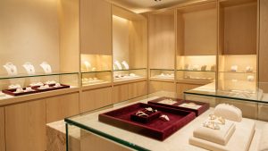 Intérieur élégant d’une boutique de bijoux avec vitrines en verre, bois clair, velours et éclairage chaleureux.